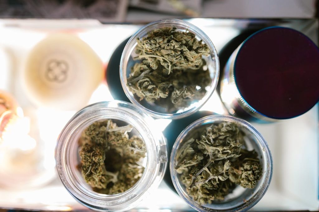 Close-up of cannabis buds in jars from above, highlighting marijuana storage.